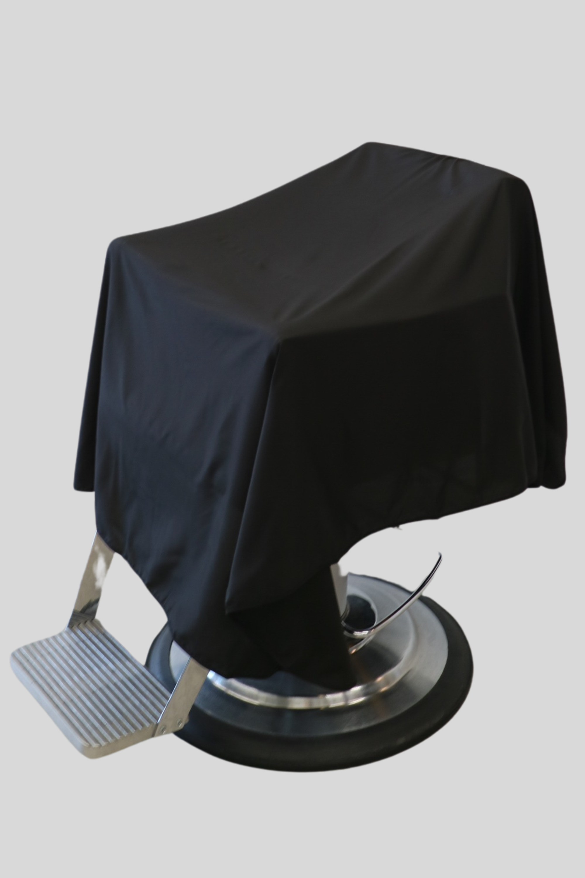 main photo of a plain black cutting cape draped over barber chair