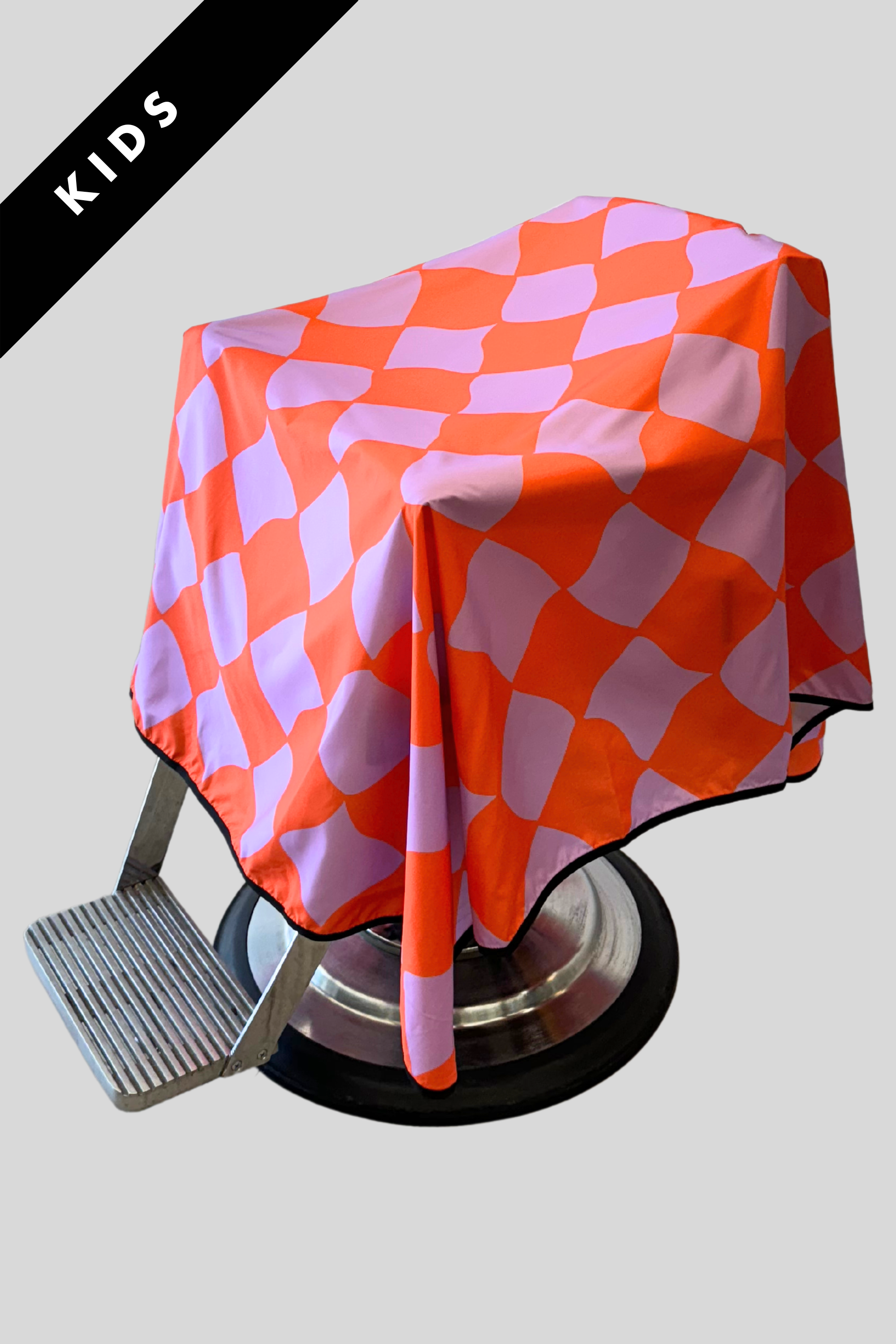 funhouse barber cutting cape for kids showing pink and purple abstract check pattern