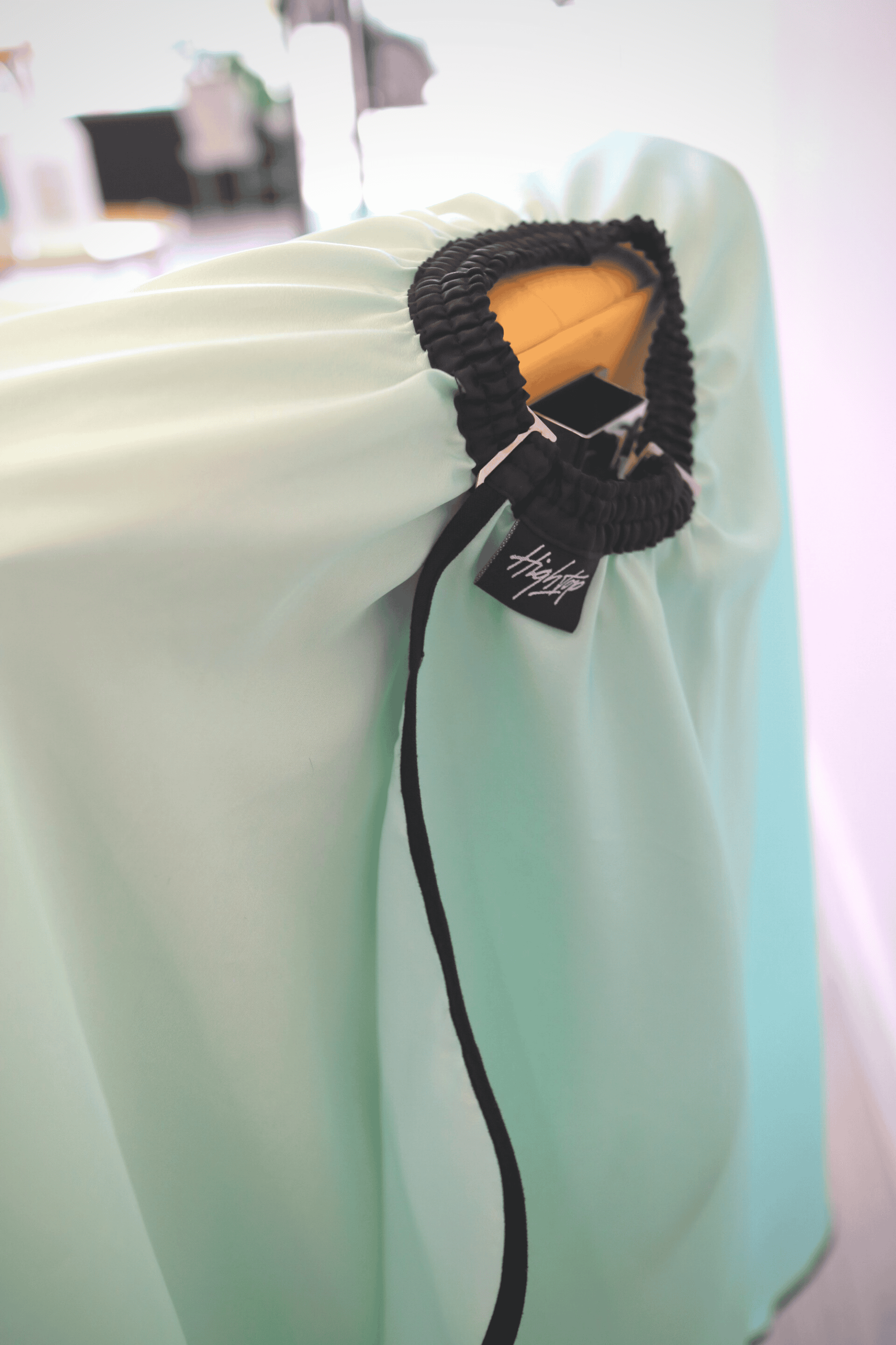 close up of mint barber cape neck with hook neck closure and elastic neck