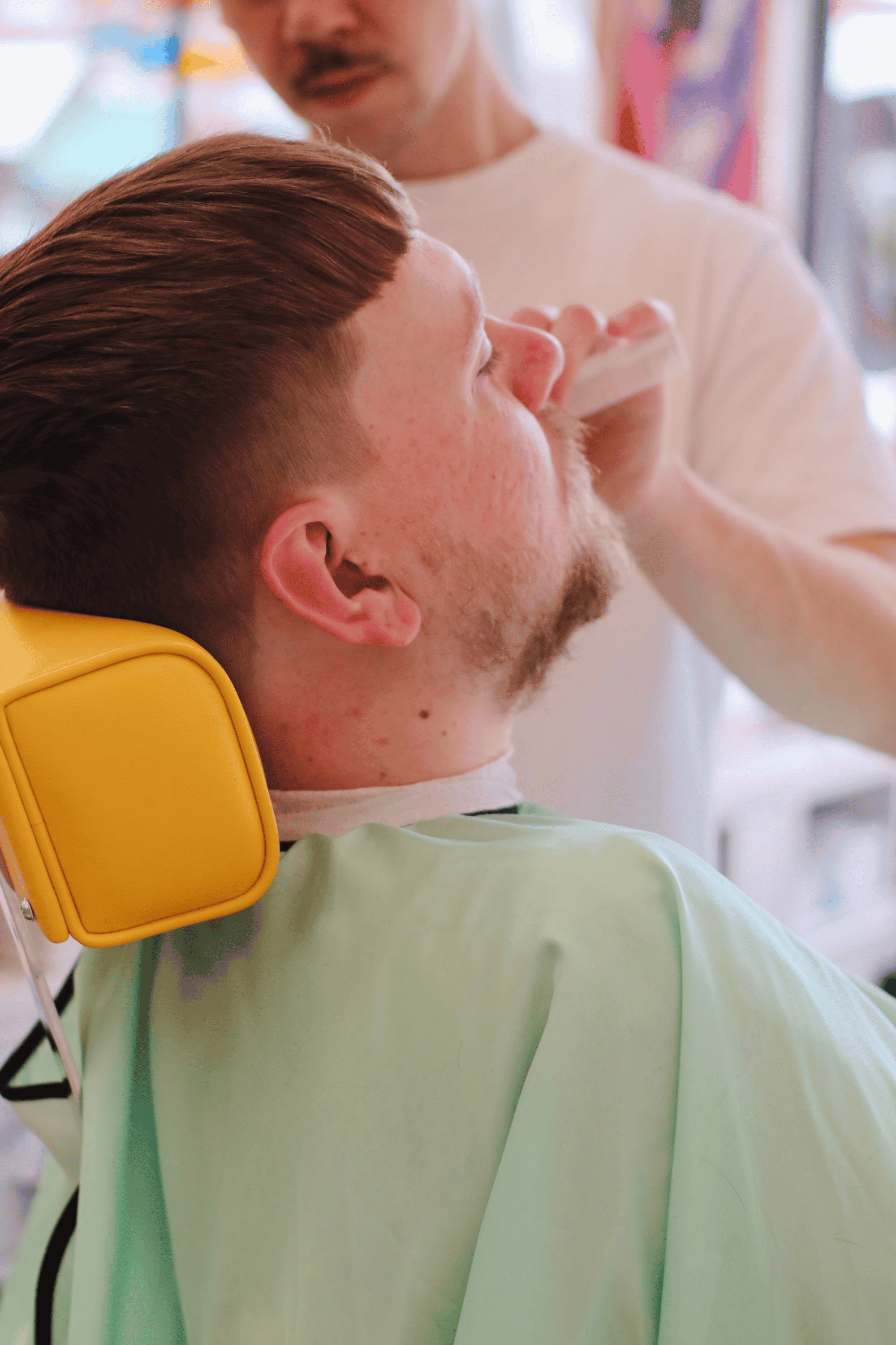 close up of client getting hair cut using the mint barber cape