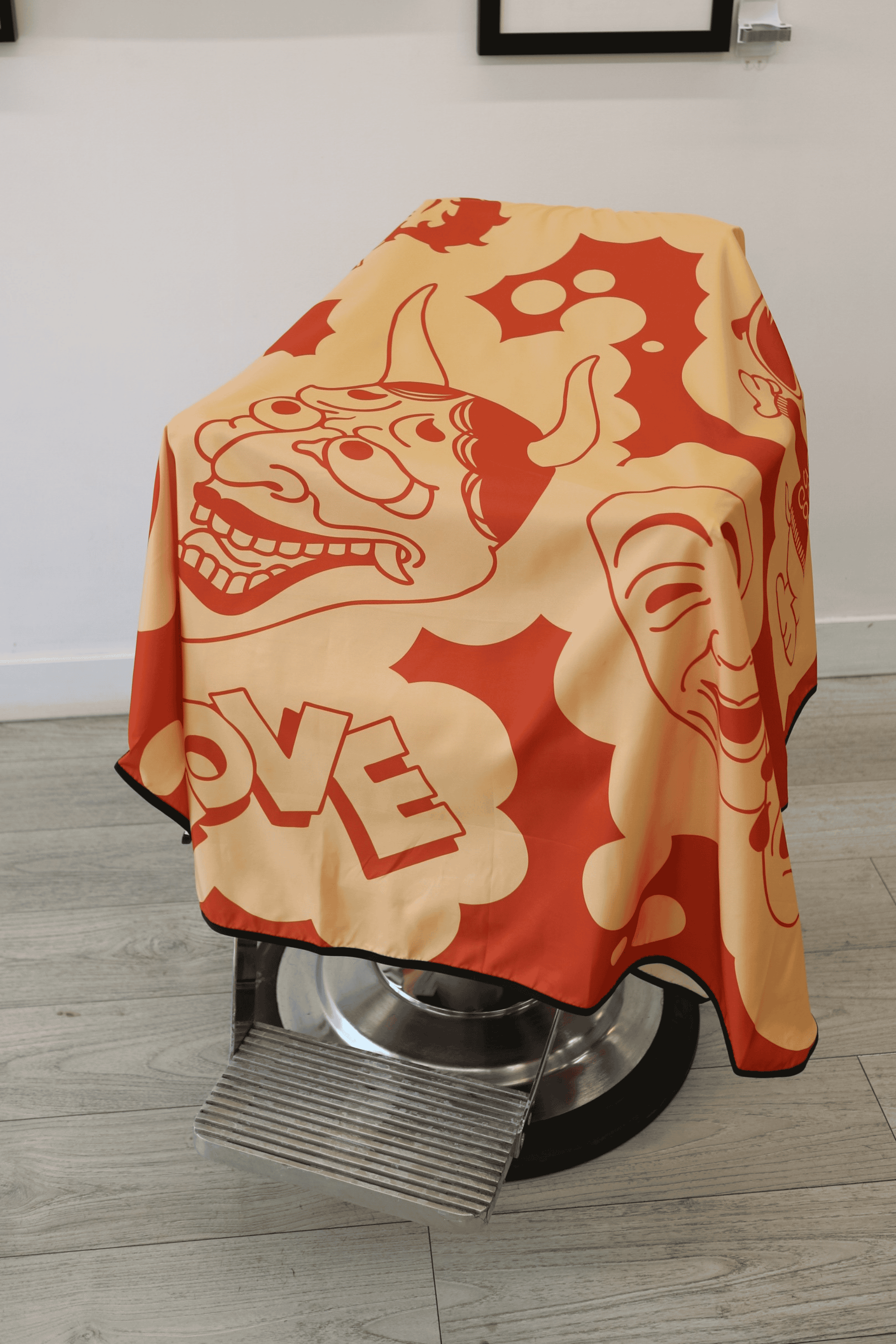 close up on japanese mask on barber cape draped on barbershop chair