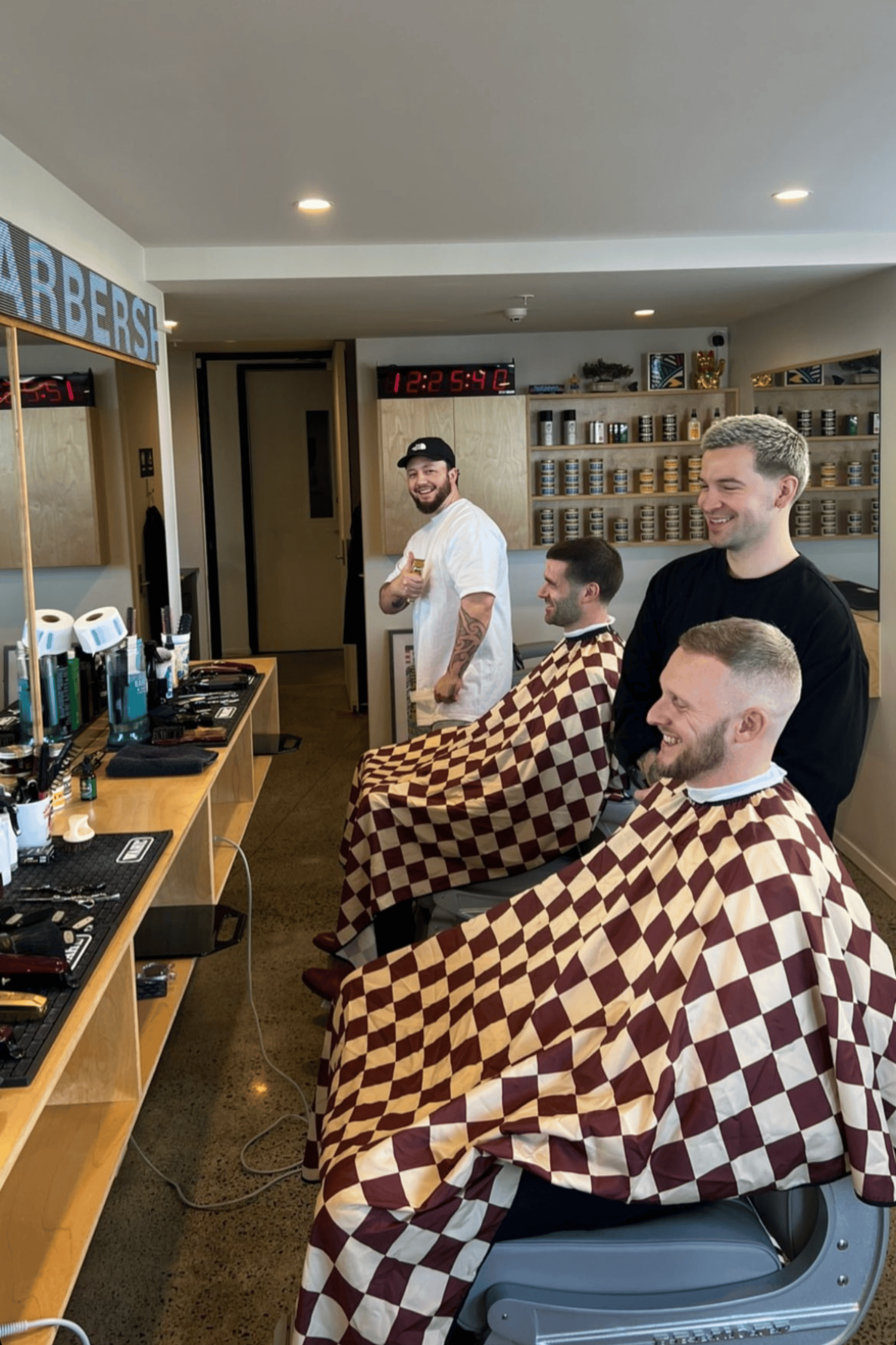 rory's barbershop in auckland using burgundy and tan checker capes