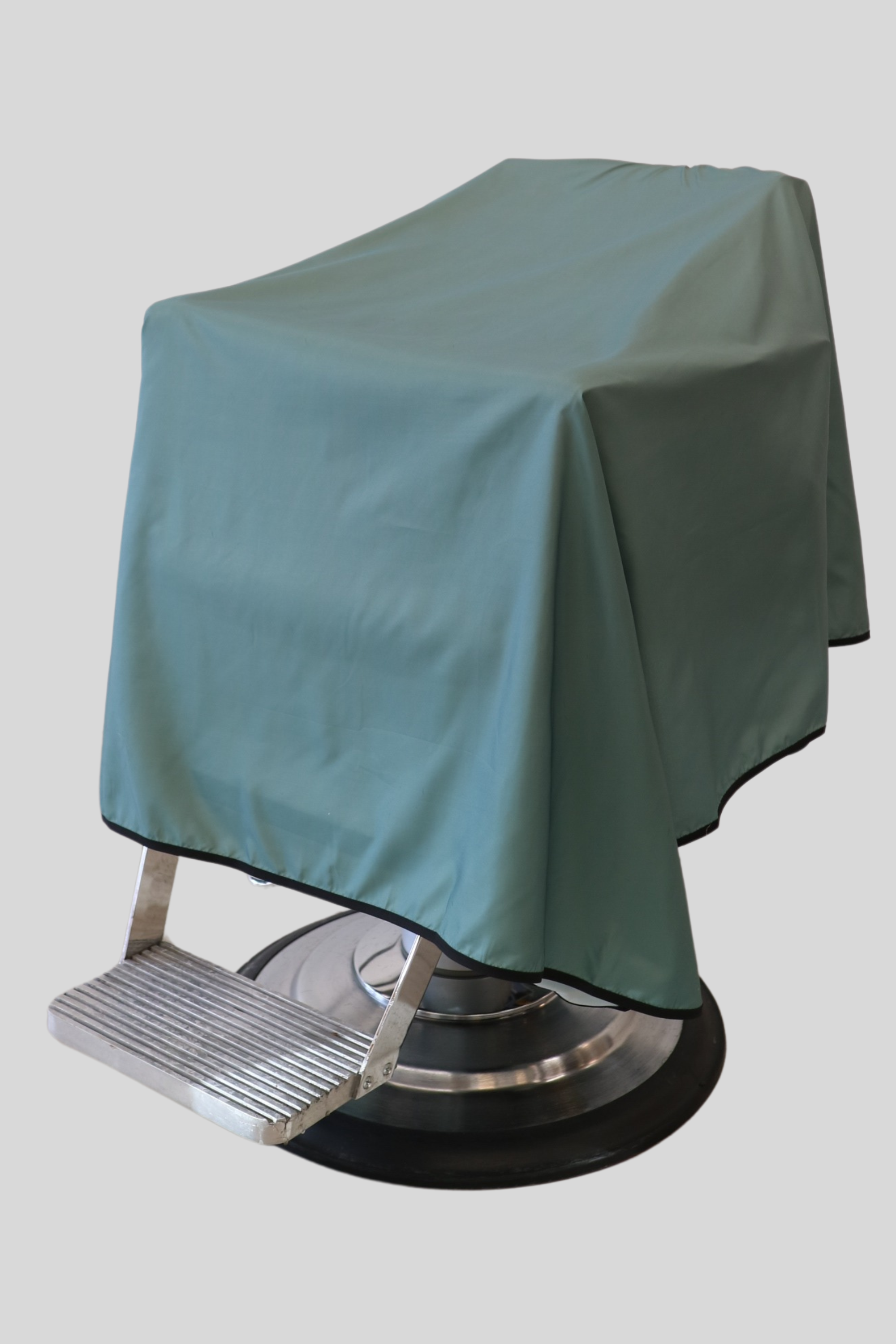 product photo of sage color full coverage barber cape draped on barber chair